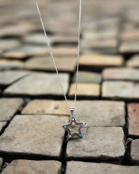 Colgante Nara con forma de estrella sobre suelo con forma de adoquín en www.tuvinculoeterno.com