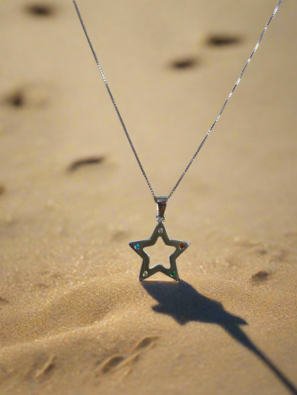 Colgante Nara con forma de estrella sobre arena de playa en www.tuvinculoeterno.com